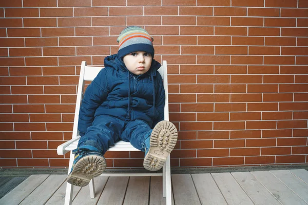 Thoughtful Boy Sitting Chair Brick Wall — Stock Photo, Image