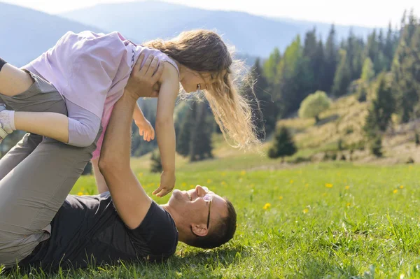 Padre Acostado Hierba Sosteniendo Riendo Risa Hija — Foto de Stock