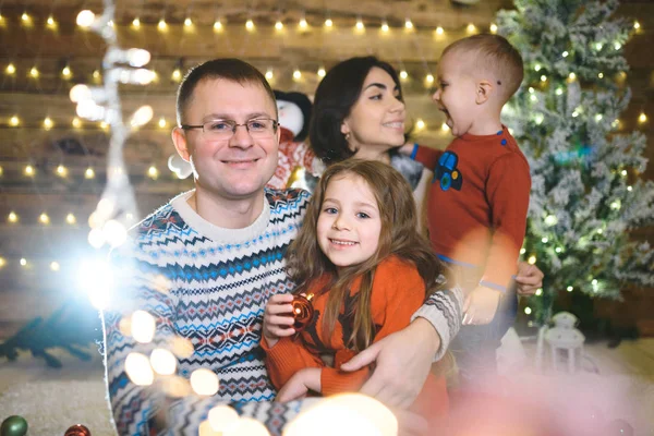 Famiglia Sorridente Seduta Insieme Nella Casa Natale Con Ghirlanda Illuminata — Foto Stock