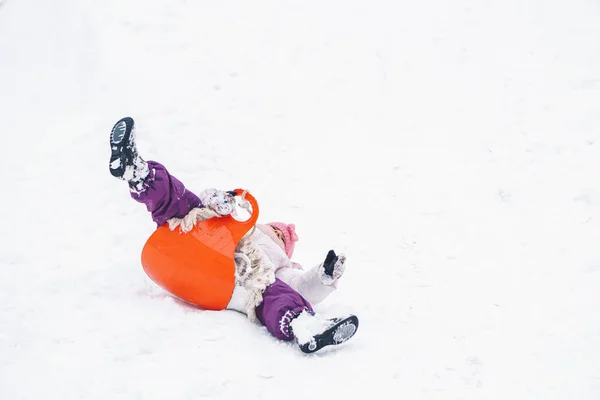 雪の中のそりから落ちて女の子 — ストック写真