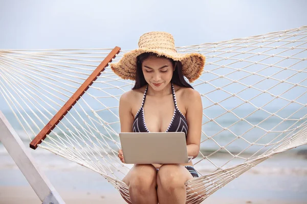 sexy bikini asian woman use laptop on tropical beach, travel the