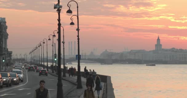 Russia, Saint-Petersburg, 16 October 2018: Dvortsovaya Embankment with a traffic in rush hour, on a background a beautiful crimson sunset, rostral colomns, cabinet of curiosities, Palace bridge