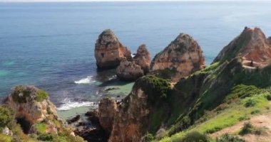Ponta da Piedade, ünlü yer Güney Portekiz, Lagos Şehir, kayalık sahil, Atlantik Okyanusu, keskin dalgaların kayalar, masmavi su, sarı çiçekler, kemer, kimse, vahşi beach