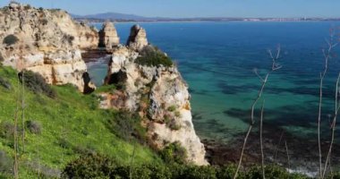 Ponta da Piedade, ünlü yer Güney Portekiz, Lagos Şehir, kayalık sahil, Atlantik Okyanusu, keskin dalgaların kayalar, masmavi su, sarı çiçekler, kemer, kimse, vahşi beach
