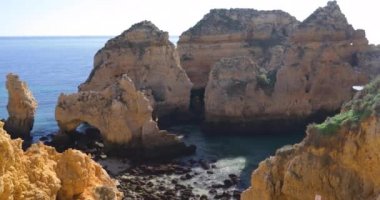 Ponta da Piedade, ünlü yer Güney Portekiz, Lagos Şehir, kayalık sahil, Atlantik Okyanusu, keskin dalgaların kayalar, masmavi su, sarı çiçekler, kemer, kimse, vahşi beach