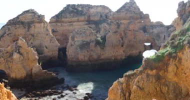 Ponta da Piedade, ünlü yer Güney Portekiz, Lagos Şehir, kayalık sahil, Atlantik Okyanusu, keskin dalgaların kayalar, masmavi su, sarı çiçekler, kemer, kimse, vahşi beach