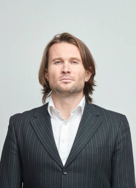 Beyaz bir arka plan iş adamı, çok şık bir kamera, beyaz gömlek, uzun kıvırcık saçlar ile acımasız adam arıyor, klasik portre, duygusuz yüzündeki siyah elbiseli yakışıklı adamlar