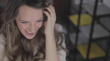 uzun kıvırcık saç flaunts ile güzel genç kız ve bir ayna önünde kapalı gösterir, flört, flört, gülümsüyor, boğucu bakmak, mutlu, kendini memnun, güzel makyaj, seksi dudaklar