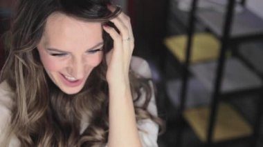 uzun kıvırcık saç flaunts ile güzel genç kız ve bir ayna önünde kapalı gösterir, flört, flört, gülümsüyor, boğucu bakmak, mutlu, kendini memnun, güzel makyaj, seksi dudaklar