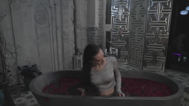 Όμορφη Νεαρή Κοπέλα Κάθεται Ένα Μπάνιο Ψηλά Νερά Κόκκινα Λουλούδια — Αρχείο Βίντεο