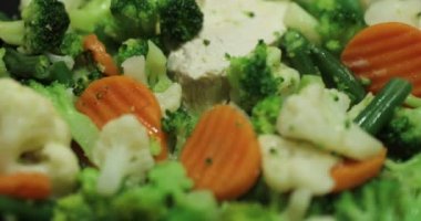 Taze kesilmiş sebze ve tavuk bir kızartma tavası, havuç, bir karnabahar, brokoli, kızarık, parlak bir çanak üzerinde kızartılır