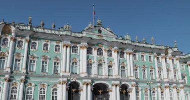 Rusya, Sankt-Petersburg, 04 Nisan 2019: Saray Meydanı, Hermitage Müzesi, güneşli bahar gününde Alexander sütun, birçok insan, turist ve şehir konukları, Kış Sarayı cephesi, Rusya bayrağı