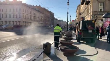 Rusya, Sankt-Petersburg, 03 Nisan 2019: güneşli bahar gününde kış sonrası şehir temizliği, Belediye hizmeti sokakları ve kaldırımları yıkıyor, Tulum, özel ekipman, bu yayalar bir sürü