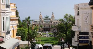Monaco, Monte-Carlo, 02 Ekim 2019: Prenslik kumarhanesinin yeşil ağaçlarla çevrili ana görüntüsünün Ultra HD videosu, yenilenmiş cephe, çeşme, Paris Oteli, güneşli bir gün.