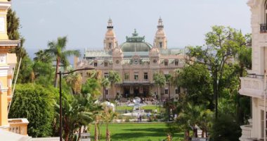 Monaco, Monte-Carlo, 02 Ekim 2019: Prenslik kumarhanesinin yeşil ağaçlarla çevrili ana görüntüsünün Ultra HD videosu, yenilenmiş cephe, çeşme, Paris Oteli, güneşli bir gün.