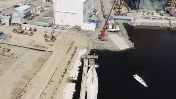 Den stora industriella kranen lyfter segelbåten och flyter den, i början av en säsong av segling, drönare utsiktspunkt, hamn Hercules — Stockvideo