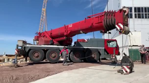 Rosja, Sankt Petersburg, 26 maja 2020: Przygotowuje ogromny dźwig przemysłowy do podnoszenia małych żaglówek i ich schodzenia do wody, kierownik żurawia przygotowuje żuraw do pracy — Wideo stockowe