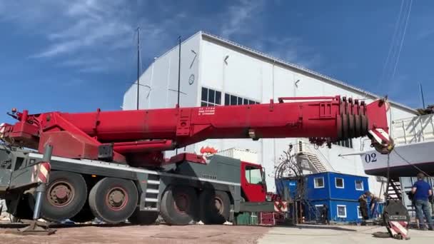 Rusko, Petrohrad, 26. května 2020: Připravuje obrovský průmyslový jeřáb pro zvedání malých plachetnic a jejich sestup do vody, jeřáb připravuje jeřáb pro práci — Stock video