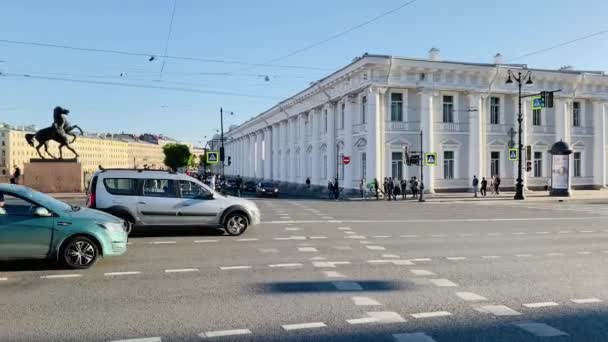 Rússia, São Petersburgo, 02 de junho de 2020: A famosa ponte Anichkov com quatro cavalos, A arquitetura de Nevsky Prospect ao pôr do sol durante a pandemia do vírus Covid-19, As pessoas atravessam a estrada, sombras longas — Vídeo de Stock