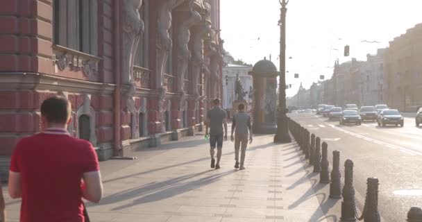 Oroszország, Szentpétervár, 2020. június 09.: Nevsky Prospect építészete naplementekor a Covid-19 vírus járványa idején, az Anichkov palota és híd homlokzata, szállítójárművek, hosszú árnyékok — Stock videók