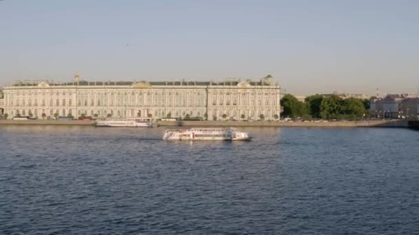 St.Petersburg,ロシア, 30 5月2019:日没のエルミタージュ美術館,冬の宮殿,水上ナビゲーション,宮殿広場,宮殿堤防,ネヴァ川のボート,緑の屋根,車のトラフィック — ストック動画