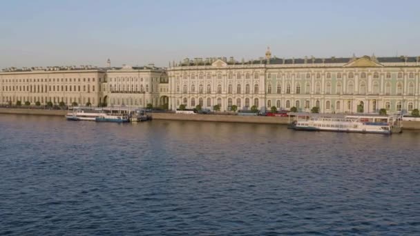 Sankt Petersburg, Rosja, 30 maja 2019: Muzeum Ermitażu o zachodzie słońca, Pałac Zimowy, żegluga wodna, Plac Pałacowy, nasyp pałacowy, łodzie na rzece Newie, zielony dach, ruch samochodowy — Wideo stockowe