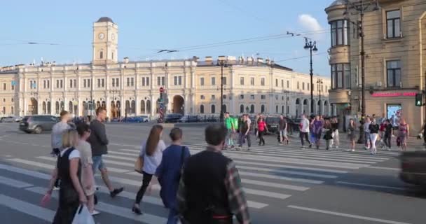 Russia, San Pietroburgo, 09 giugno 2020: Piazza Vosstaniya, stazione ferroviaria di Mosca, L'architettura del Nevsky Prospect al tramonto, Molti attraversano la strada pedonale, lunghe ombre, traffico, polvere, rallentatore — Video Stock