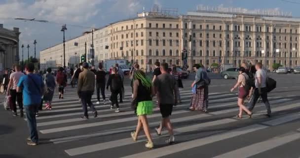 俄罗斯圣彼得堡，2020年6月9日：莫斯科火车站Vosstaniya广场，日落时Nevsky Prospect的建筑，许多人过马路，长长的阴影，交通，灰尘，慢动作 — 图库视频影像