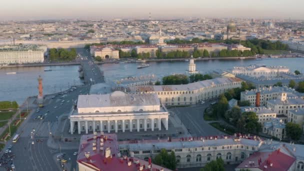 Vídeo aéreo del antiguo edificio de la Bolsa de Valores y columnas Rostral, centro de San Petersburgo al atardecer, Rusia, barcos en el río Neva, puentes, edificio del Almirantazgo, catedral de Isaac — Vídeo de stock