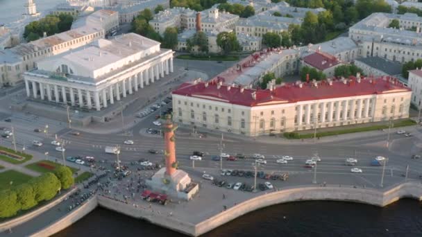 Vidéo aérienne du bâtiment de la Vieille Bourse et des colonnes Rostrales, centre de Saint-Pétersbourg au coucher du soleil, Russie, bateaux sur la rivière Neva, ponts — Video