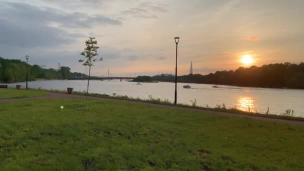 Rusia, San Petersburgo, 10 de junio de 2020: El barco con un surfista en una ola baja por el río al atardecer, puente, rascacielos en el fondo, centro de Lakhta — Vídeo de stock