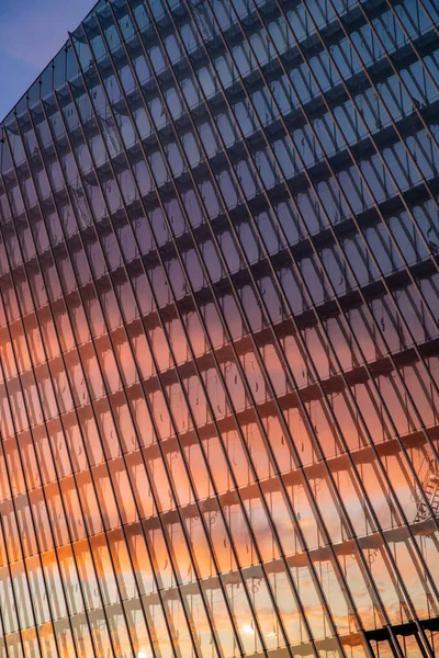 Reflejo del cielo del atardecer en una fachada de cristal del edificio, rascacielos al atardecer, cielo rosado — Foto de Stock