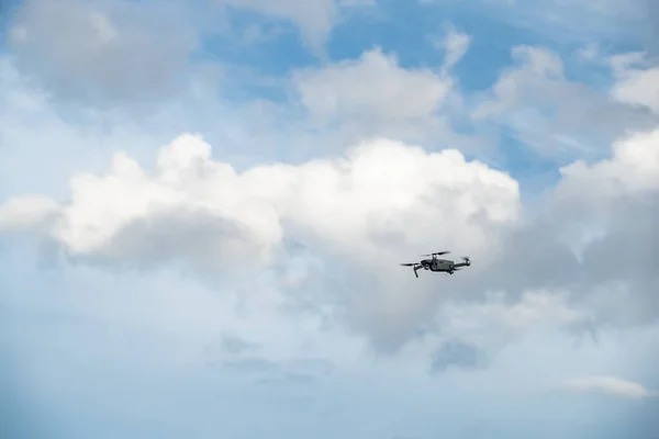 The flying soaring drone in the sky, the blue sky with white clouds, sunny weather, Turning propellers, nobody — Stock Photo, Image