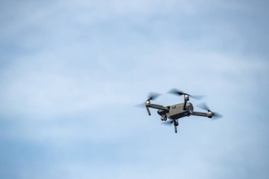 Gökyüzünde uçan dron, beyaz bulutlu mavi gökyüzü, güneşli hava, dönen pervaneler, hiç kimse