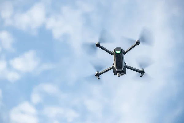 Le drone volant dans le ciel, le ciel bleu avec des nuages blancs, le temps ensoleillé, les hélices tournantes, personne — Photo