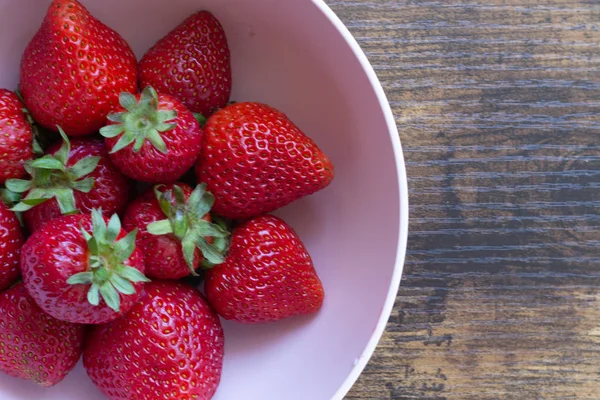 Pembe bir kase deseniniçinde çilek bir kase yakın.