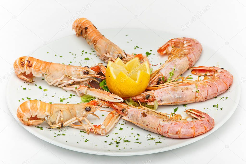 Italian food, grilled shrimps and prawns served on white plate, isolated on white background