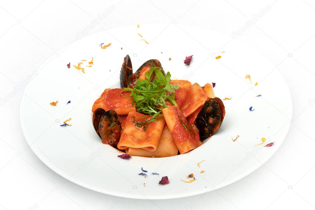 Italian food, Paccheri pasta with fresh mussels and rocket salad, served on white plate, isolated on white background