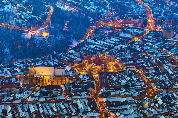 Brasov, Transylvania. Romania. Panoramic view of the old town and Council Square, Aerial twilight cityscape of Brasov city, Romania