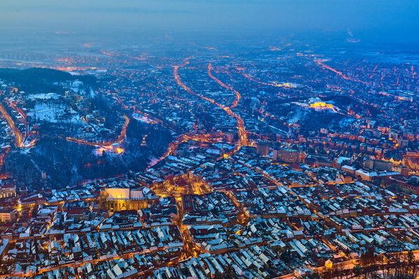 A panoramic view of the city Brasov at sunset above the Mount Tampa in the winter time