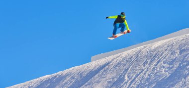 Madonna di Campiglio dağ kayak merkezinde arka planda derin mavi gökyüzü ile havada atlama Madonna Di Campiglio, İtalya-21 Kasım 2014:Snowboarder