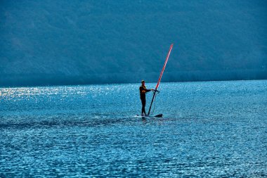 Torbole, Lago di Garda, İtalya - 19 Ekim 2018: adet rüzgar sörfü sörf rüzgar üzerinde dalgalar içinde Garda Gölü, eğlence su sporları, aşırı spor eylem. Eğlence spor etkinliği. Sağlıklı aktif yaşam tarzı. Yaz eğlenceli macera. Hobi