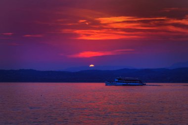 Güzel bir gün batımı Sirmione sul Garda için uzaktan bir Yelkenli tekne ile bir görünüm