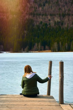 Sarı saçlı güzel ve volkanik göl Saint Ana kış döneminde hayran olan genç kadın. Saint Ana volkanik göl Tusnad Romanya