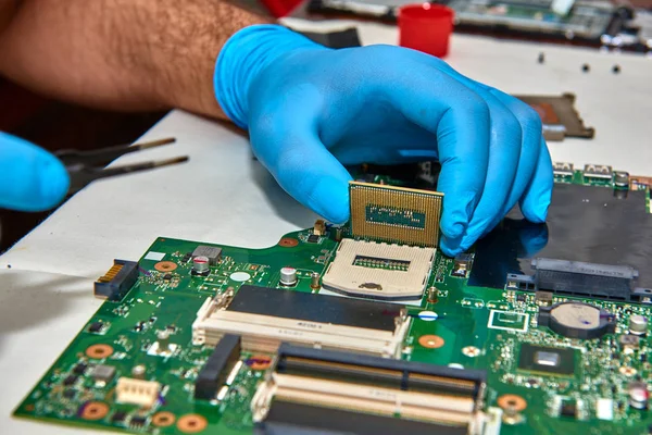 Hands of the technician repairing a computer, Technician who changes the computer's processor, Close up with selective focus