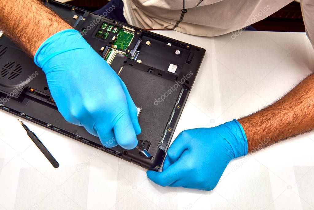 Hands of the technician repairing a computer, Professional laptop repair,Close up with selective focus