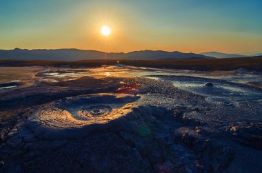 Romanya, Berca, Buzau, Vulcanii Noroiosi çamurlu Volkanlar Ulusal rezervasyonunuzu yaparken güneş doğuyor. Çamurlu volkanlar manzara.
