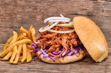 Barbekü çekti domuz sandviç ile barbekü sosu, kırmızı cabbageonion, sos ve patates salatası ahşap arka plan, Fast food