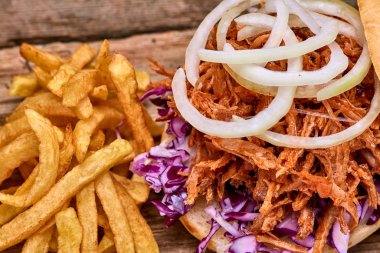 Barbekü çekti domuz sandviç ile barbekü sosu, kırmızı cabbageonion, sos ve patates salatası ahşap arka plan, Fast food