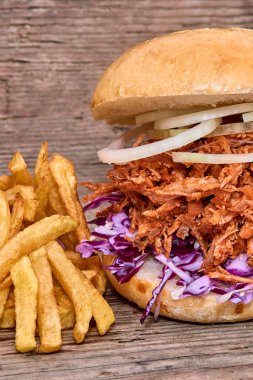Barbekü çekti domuz sandviç ile barbekü sosu, kırmızı cabbageonion, sos ve patates salatası ahşap arka plan, Fast food